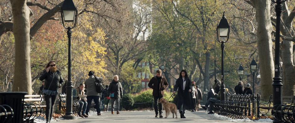 Kate holds Pizza Dog's leash as she and Clint walk through the park.