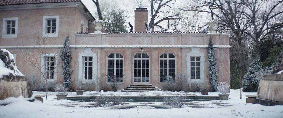 Sonya and Yelena run across the rooftop of the house to a second story window.