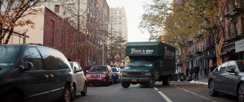 The Trust a Bro Moving Company truck turns off the road into the parking lot.