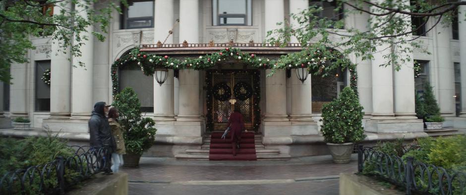 Eleanor walks up the steps to the fancy building.