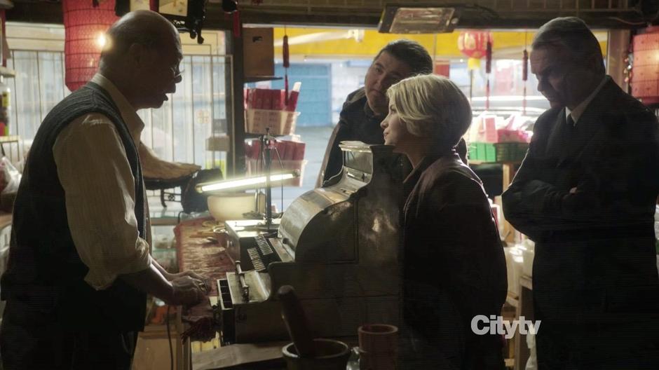 The team interviews the store owner about Johnny McKee.