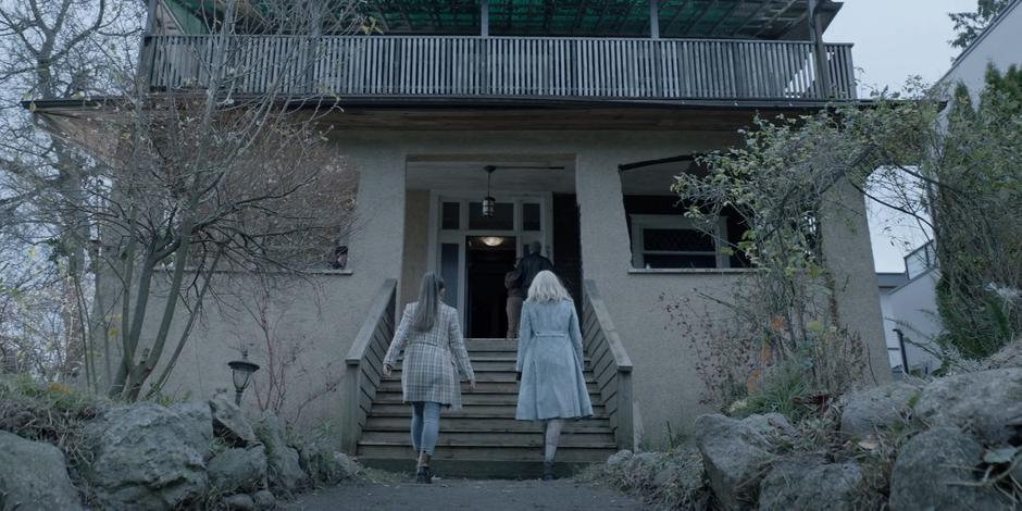 Mary and Alice walk up the steps to where two people are talking on the porch.