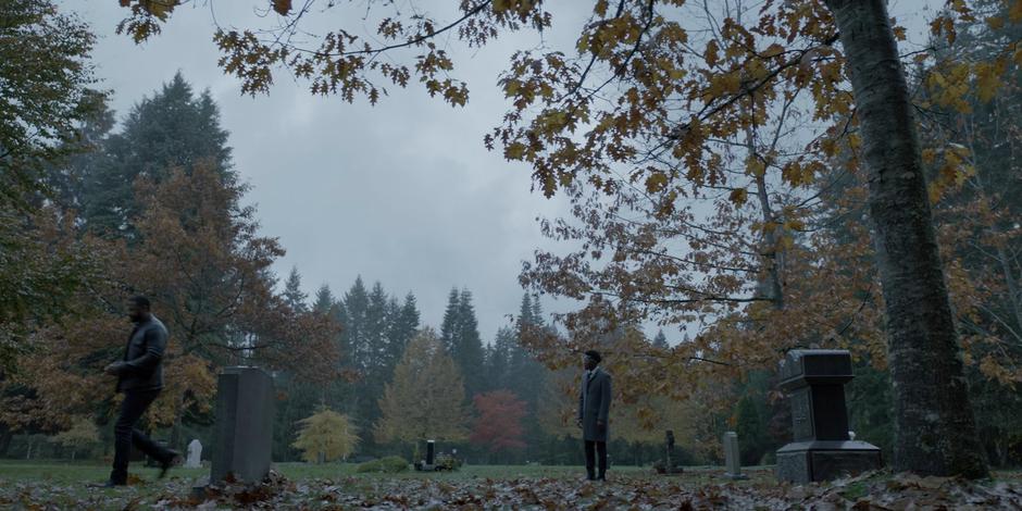 Luke watches as Diggle walks away after their conversation in front of his father's gravestone.