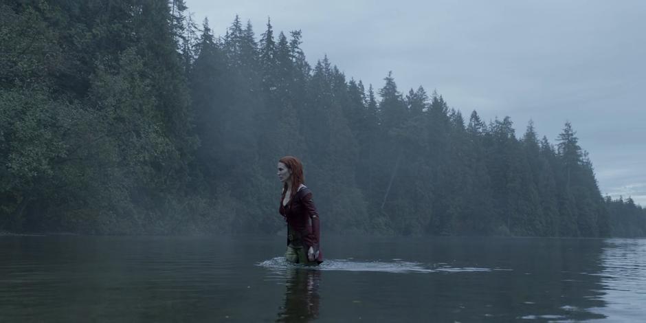 Pam walks out of the water and onto the beach.