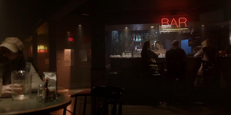 Mary and Alice sit at the bar with a man between them.