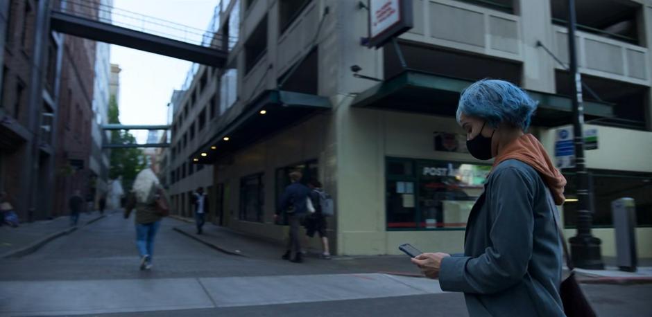 Angela looks down at her phone as she follows the directions.