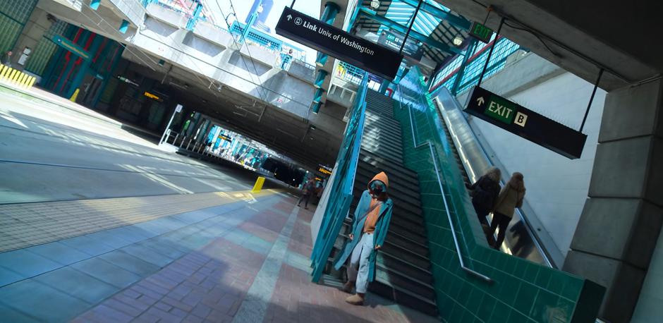 Angela steps off the stairs in the station and turns the corner.