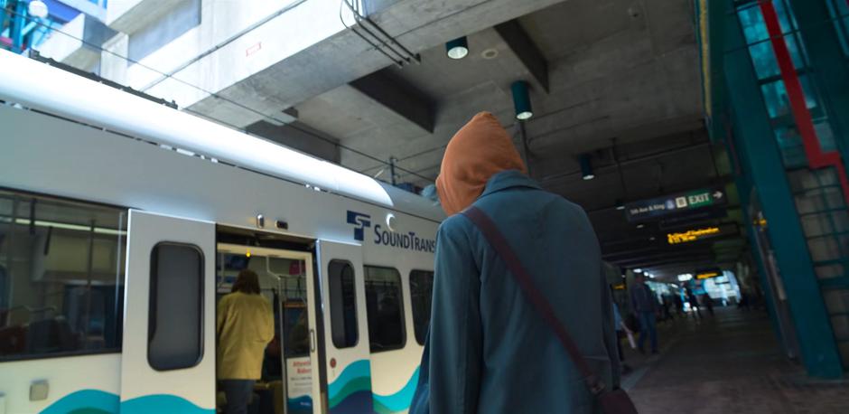 Angela walks to the waiting light rail.