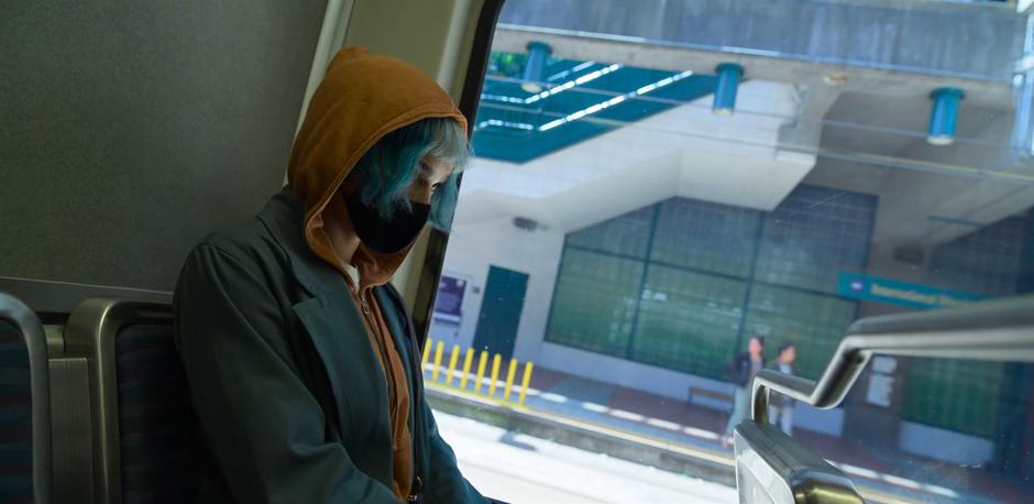 Angela sits in the back row and waits for the light rail to leave.