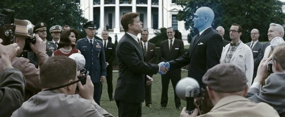Dr. Manhattan shakes JFK's hand.