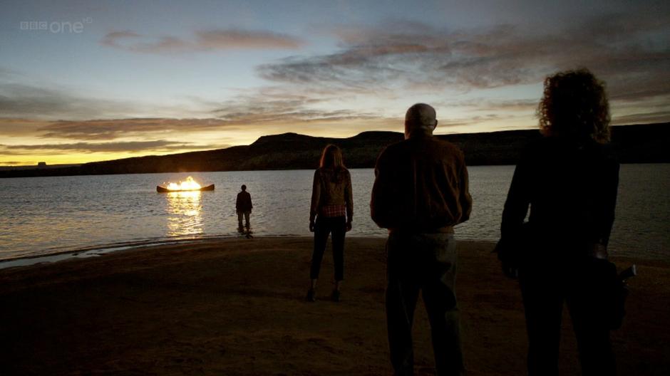 Amy, Rory, River, and Canton Delaware watch the Doctor's funeral pyre.