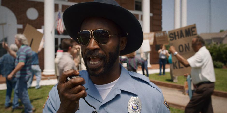 Officer Powell radios Hopper for assistance with the protest at town hall.