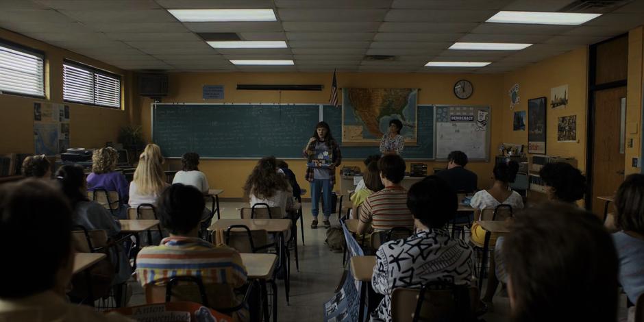 El stands at the front of class showing her diorama about Hopper.