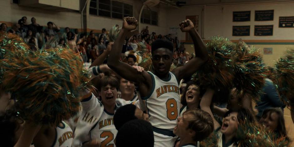 The other members of the basketball team lift Lucas into the air after his game-winning basket.