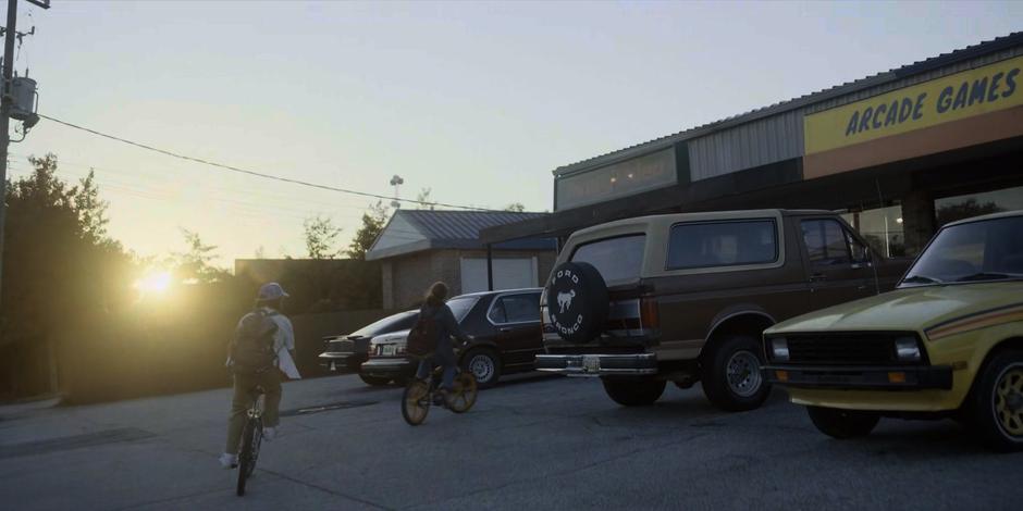 Dustin and Max ride their bikes to the video store.