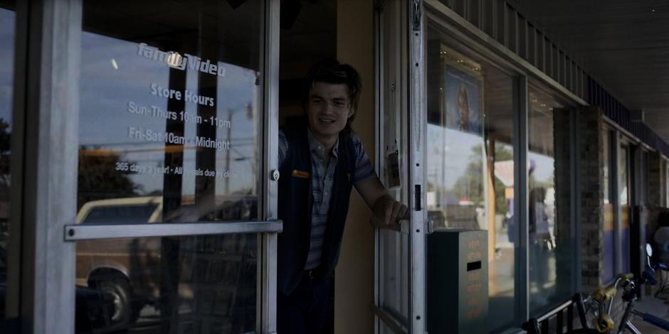 Steve leans out the door as the cute girl leaves after renting a video.