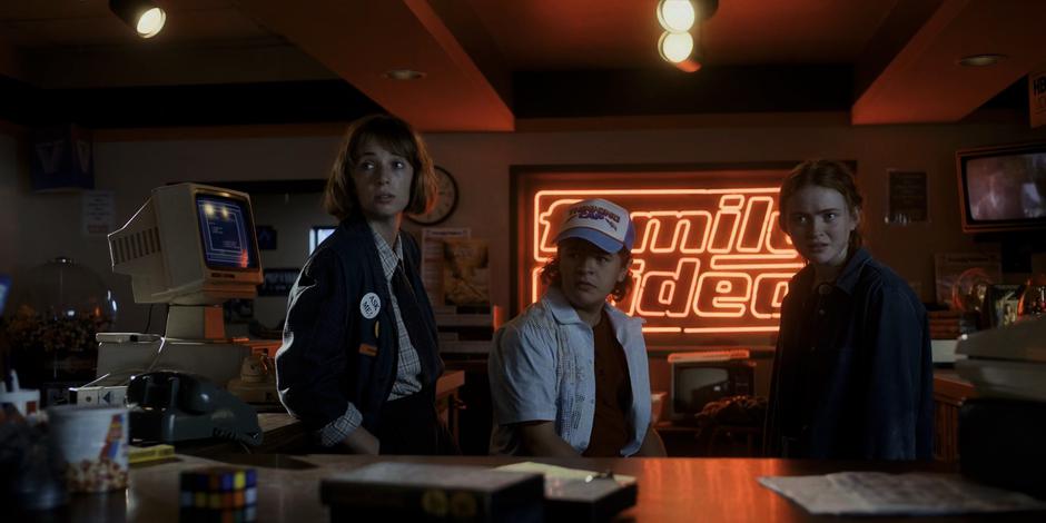 Robin, Dustin, and Max give Steve a look from behind the counter.