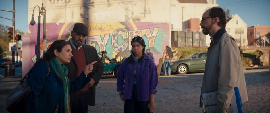 Kamala watches as her parents argue with the proctor as a tow truck prepares his car behind them.