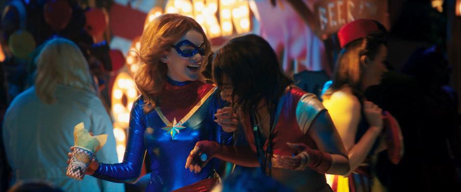 Zoe laughs with another attendee while wearing a Captain Marvel cosplay of her own.
