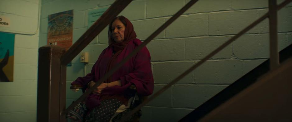 An older woman rides the stair life up to the main floor.