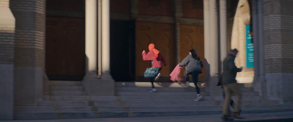 Nakia and Kamala run up the steps to the mosque entrance.