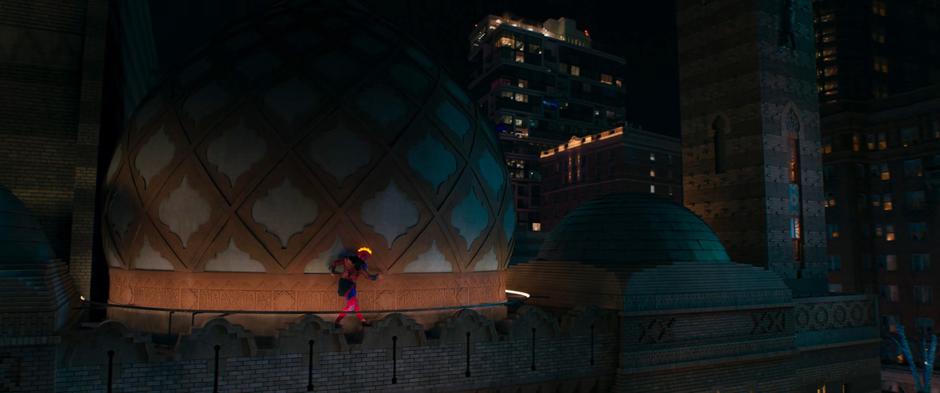 Kamala slowy skirts around the edge of the roof as she makes her way towards the kid.