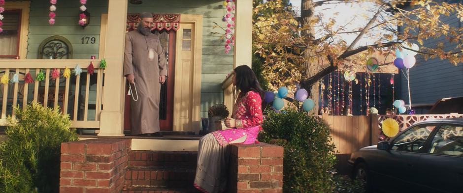 Sheikh Abdullah approaches Kamala as she is sitting on the porch of her house.