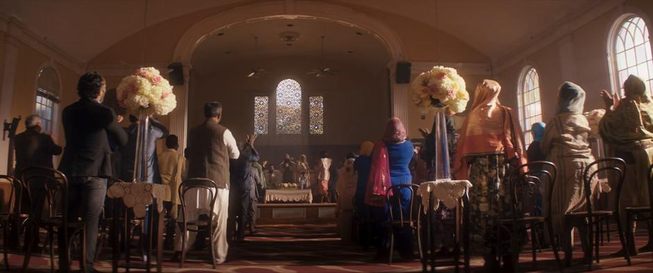 People stand and clap as the marriage ceremony is finished.