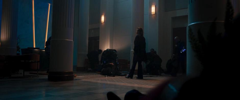 Agent Deever strolls through the lobby as her agents arrest the Jinn.