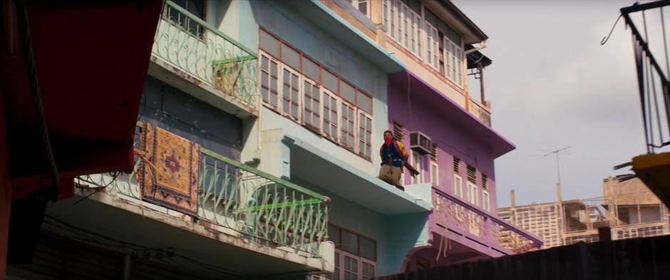 Waleed runs across the overhang between two balconies.