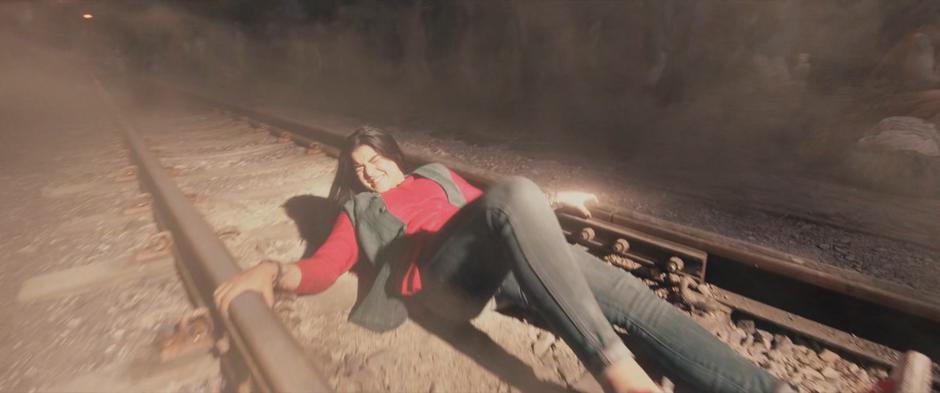 Kamala wakes up to a bright light in her face as she lies on some train tracks.