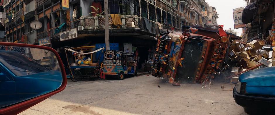 The truck crashes into the ground spilling its contents into the street.