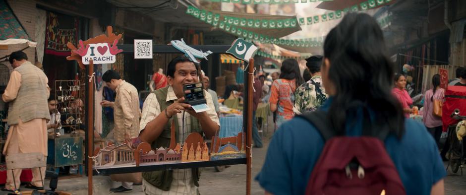 A man takes a photo of Kamala with a Polaroid camera.