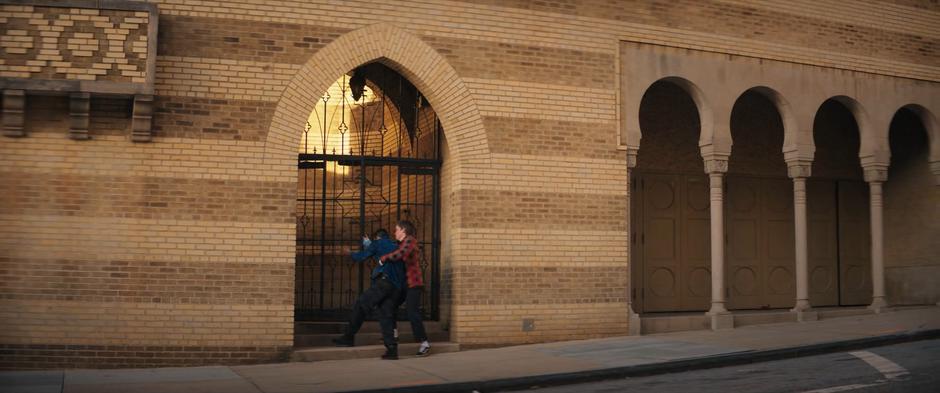 Bruno helps Kamran enter through the mosque's side door.