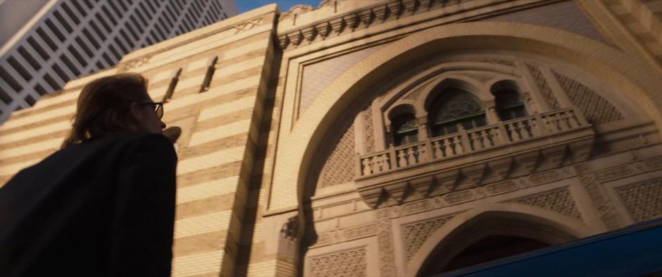 Agent Deever looks up at the front of the building after getting out of her vehicle.