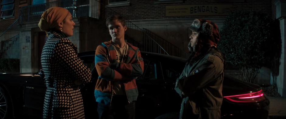 Nakia, Bruno, and Kamala talk next to Kamran's abandoned car in front of the school.