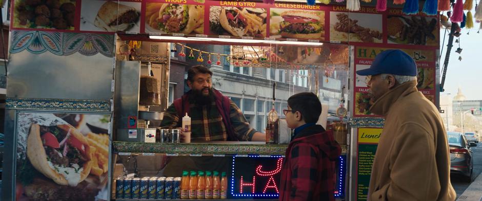 The Gyro King takes an order from two people at his stand.