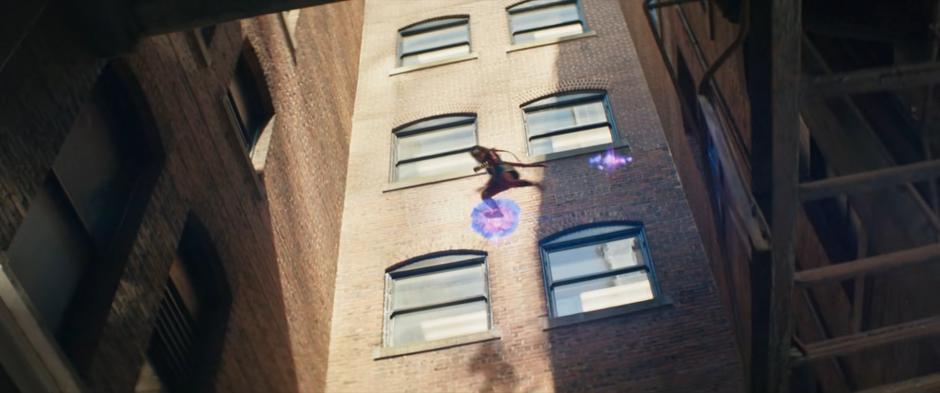 Kamala leaps from platform to platform as she descends into the alley.