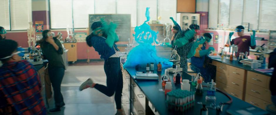 Kamala leaps back as her science experiment explodes into a blue blob.