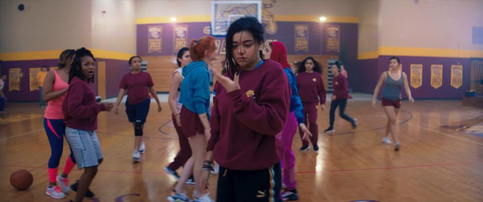 Kamala checks on her bloody nose after getting hit with a dodgeball in gym while Nakia argues with Zoe behind her.