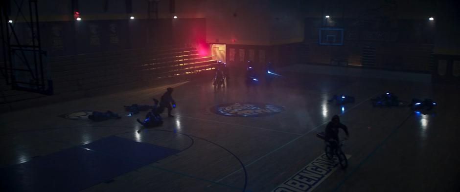 Zoe bikes through the gym causing a bunch of DODC agents to hit one another with their concussive weapons.