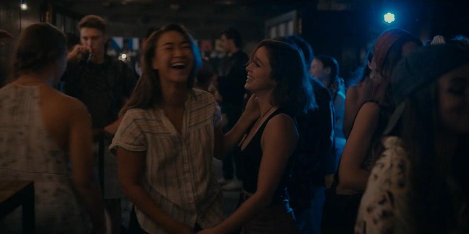 Bea and Ava laugh as they drunkenly dance together.