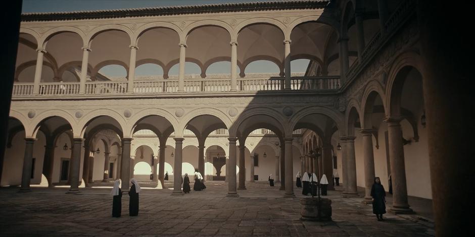 Camila walks through the courtyard towards the library.