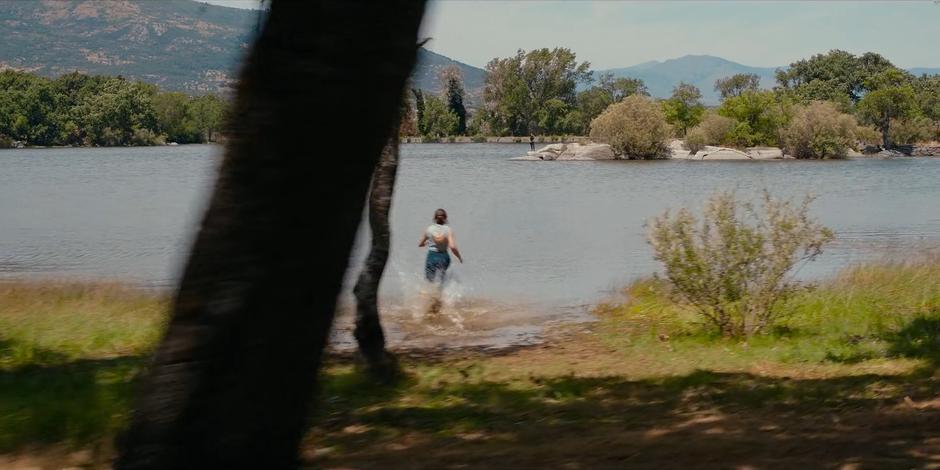 Ava begins to run into the lake as Bea watches from a rock across the water.