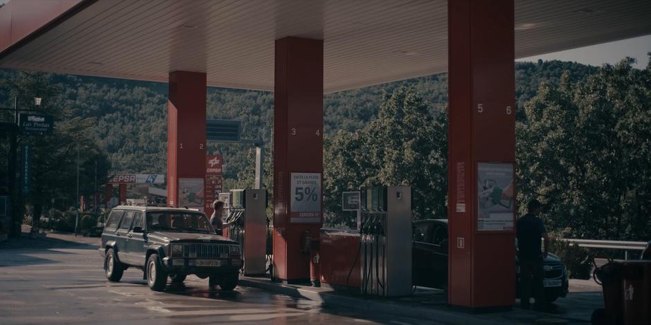 Miguel finishes pumping gas as Ava and Bea finish their conversation.