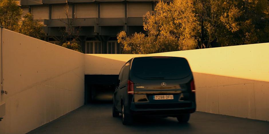 The van drives down the ramp into the parking garage beneath the building.