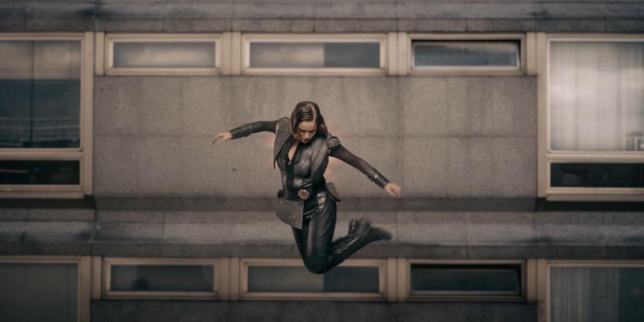 Ava looks to the ground far below after running through the outer wall of the hotel.