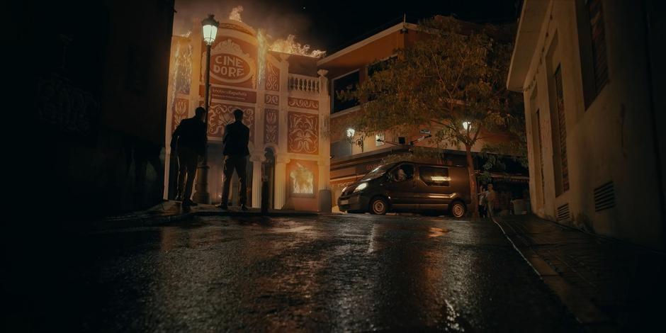 Yasmine drives the van past the front of the burning cinema.