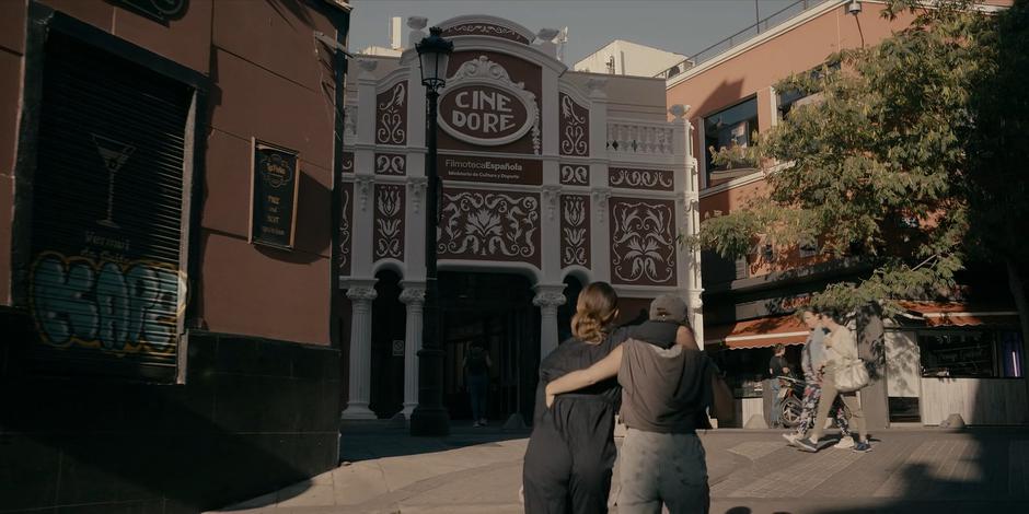 Bea and Ava clutch one another as they head up the street towards the cinema.