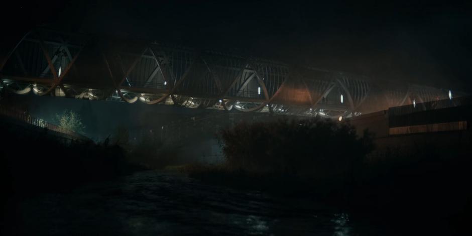 Establishing shot of the bridge over the river at night.